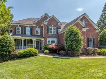 Stately two-story brick home with a covered front porch, manicured lawn, and mature landscaping at 2301 Keara Way, Charlotte, NC 28270