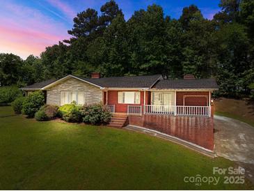 Charming brick home with stone accents, landscaped yard and a covered front porch perfect for relaxing at 24501 Canton Rd, Albemarle, NC 28001