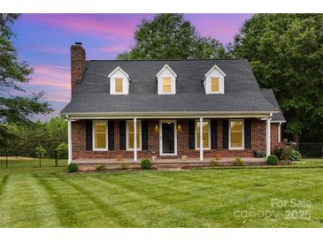 Charming brick home featuring a manicured lawn, black shutters and a covered porch in a quiet neighborhood at 3049 Stablegate Dr, Gastonia, NC 28052