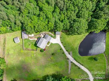 Beautiful aerial view of estate home with pond, acreage and mature trees at 4111 Jenkins Rd, Marshville, NC 28103