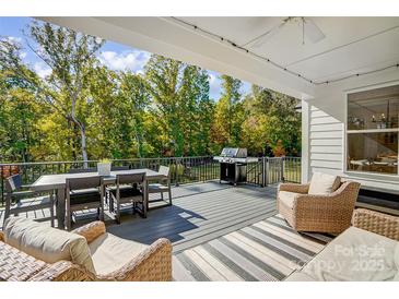 Outdoor deck with a dining table, grill, and comfortable seating, perfect for entertaining and relaxation at 4116 Spring Cove Way, Belmont, NC 28012