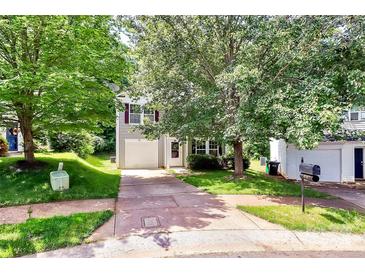 Charming two-story home with a well-maintained lawn, mature trees, and a private driveway leading to an attached garage at 459 Presidents Ct, Charlotte, NC 28217