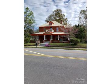 Charming brick home featuring a wide front porch, complemented by classic architectural details at 514 N Main St, Mount Gilead, NC 27306