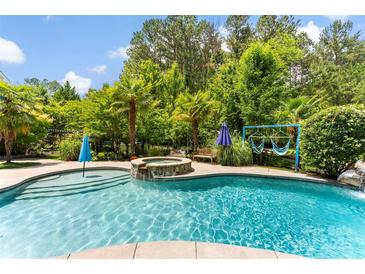 Inviting backyard pool and spa surrounded by lush greenery creates a private and relaxing oasis at 5418 Commodore Pl, Clover, SC 29710