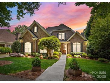 Charming brick home with lush landscaping and a beautiful walkway leading to the front door at 8701 Highgrove St, Charlotte, NC 28277