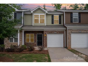 Charming townhouse with brick facade, single car garage and well-maintained landscaping at 9203 Grand Valley Dr, Charlotte, NC 28213