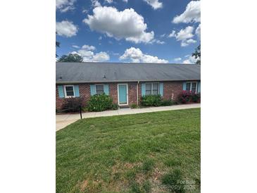 Charming brick townhouse with a well-manicured lawn and lovely turquoise shutters and front door at 1326 5Th Ne St, Hickory, NC 28601