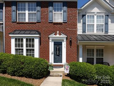Inviting townhome with brick facade, blue shutters, and a well-maintained lawn and welcome front door at 2147 Lake Breeze Ln, Denver, NC 28037