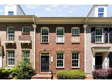 Charming brick townhome featuring a black front door, well-maintained landscaping, and large windows for natural light at 2485 Shanklin Ln, Denver, NC 28037