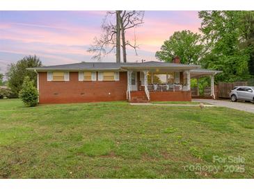 Charming red brick home featuring a cozy front porch and a convenient carport with a well-maintained lawn at 2885 Wright Ave, Salisbury, NC 28147