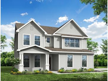 Charming two-story home with a covered front porch and landscaped yard offers great curb appeal at 3229 Bozeman Ct # 13, Stanley, NC 28164