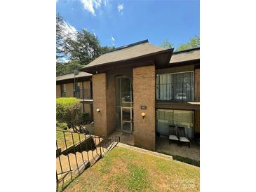 Attractive building exterior, featuring brick facade, covered walkways, and well-maintained landscaping at 415 Orchard Trace Ln # 1, Charlotte, NC 28213