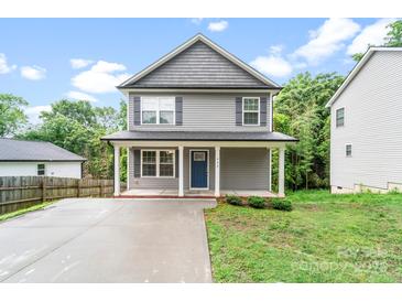Charming two-story home features a blue front door, covered porch with white columns, and a well-maintained yard at 668 Smith St, Kannapolis, NC 28083
