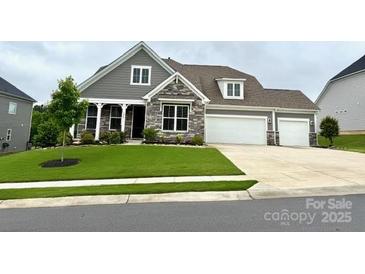 Charming home featuring stone accents, a two-car garage, and a well-manicured front yard at 7049 Irongate Dr, Indian Land, SC 29707