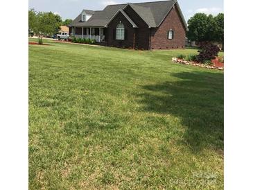 Charming brick home with a cozy front porch and well-maintained landscaping, set on a lush green lawn at 8520 Wright Rd, Kannapolis, NC 28081