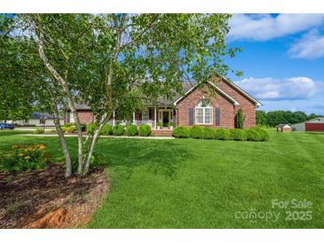 Charming brick home with a well-manicured lawn and lush landscaping at 8520 Wright Rd, Kannapolis, NC 28081
