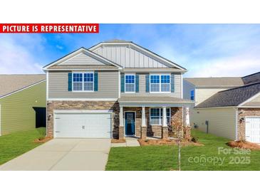 Charming two-story home featuring stone accents, a two-car garage, and a well-manicured lawn at 1340 Secrest Commons Dr, Monroe, NC 28112