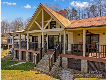 Charming exterior of the lake house with a metal roof, stone foundation, and inviting porch at 3062 Bass Dr, Sherrills Ford, NC 28673