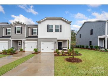 Charming townhome featuring a single-car garage and well-manicured lawn, perfect for suburban living at 518 Tayberry Ln, Fort Mill, SC 29715