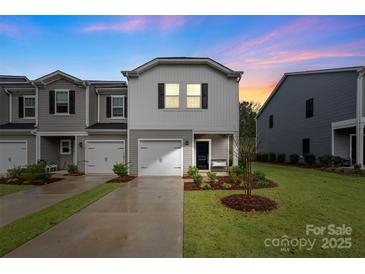 Charming townhome featuring a single-car garage and well-manicured lawn, perfect for suburban living at 518 Tayberry Ln, Fort Mill, SC 29715
