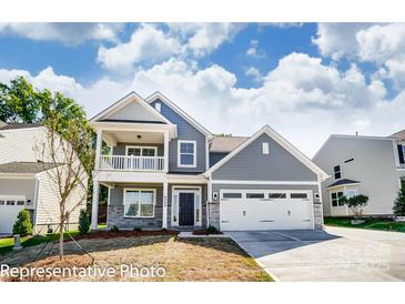 Charming two-story home featuring a covered porch, a two-car garage, and a beautifully landscaped front yard at 6027 Veld Ct # 82, Charlotte, NC 28215