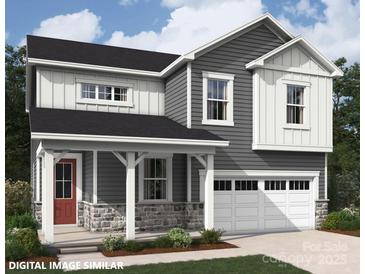 Charming two-story home featuring gray siding, stone accents, a covered porch, and an attached two-car garage at 9858 Quercus Ln, Huntersville, NC 28078