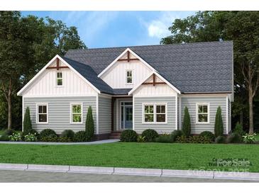 Charming one-story home with light-green siding, gray roof, manicured lawn, and complemented by mature trees at 1061 The Glen St, Statesville, NC 28677