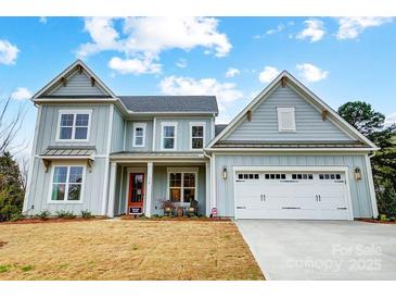 Charming two-story home with a red front door, white garage door, and light blue siding at 110 Adalyn Ivy Ln # 1, Mooresville, NC 28115