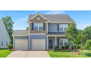Charming two-story home featuring light blue siding, a two-car garage, and a welcoming front entrance at 129 Canada Dr # 85, Statesville, NC 28166