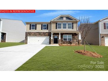 Charming two-story home with stone accents, a well-manicured lawn, and an attached two-car garage at 133 Way Cross Ln, Troutman, NC 28166