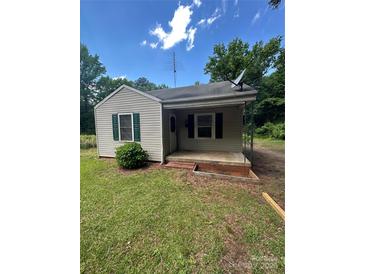 Charming home featuring vinyl siding, a covered front porch, and small landscaped area at 407 Lincoln St, Wadesboro, NC 28170