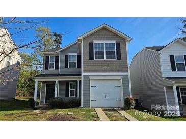 Charming two-story home featuring a one-car garage and landscaped front yard at 5823 Natick Dr, Charlotte, NC 28214