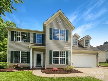 Charming two-story home featuring green shutters, a well-manicured lawn, and an attached two-car garage at 10406 Baskerville Ave, Charlotte, NC 28269