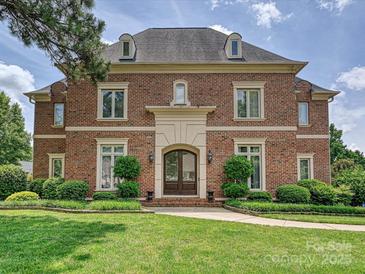 Stately brick home featuring a manicured lawn, classic architectural details, and a welcoming entrance at 11321 James Jack Ln, Charlotte, NC 28277