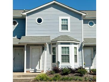 Charming townhome with light blue siding, a bay window, and a well-maintained front yard with mature landscaping at 1430 River Dr # 14, Belmont, NC 28012
