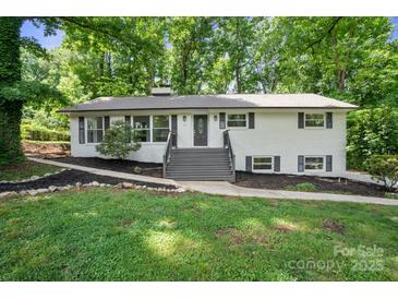 Charming home featuring a landscaped front yard, and a welcoming entrance with freshly painted stairs at 218 Kingsway Cir, Charlotte, NC 28214