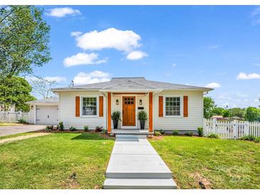 Charming single-story home features a well-manicured lawn, updated shutters, and a welcoming front porch at 411 W Sycamore St, Lincolnton, NC 28092