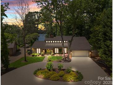 Stunning lakefront home with lush landscaping, inviting entrance, and charming stone and siding exterior at 570 Blue Heron Rd, Salisbury, NC 28146