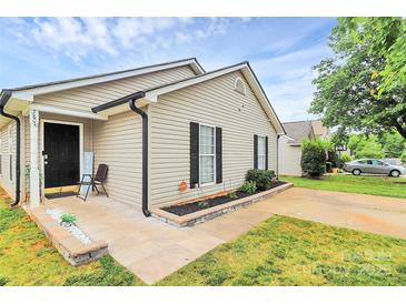 Charming single-story home with light beige siding, black shutters, and well-maintained front yard at 5804 Fairchase Ave, Charlotte, NC 28269