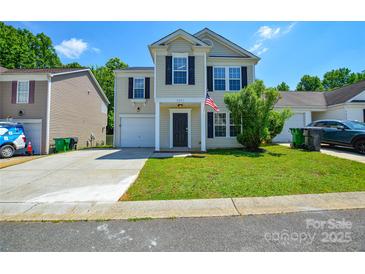 Charming two-story home featuring a well-manicured lawn, attached garage, and traditional design with black shutters at 7311 Fig Ln, Charlotte, NC 28215