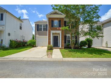 Charming two-story home featuring a brick facade, attached garage, and well-maintained lawn at 7711 Brisbane Ct, Charlotte, NC 28215