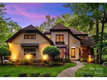 Charming two-story home with landscaped yard and stone walkway, illuminated by exterior lighting at dusk at 8534 Highgrove St, Charlotte, NC 28277