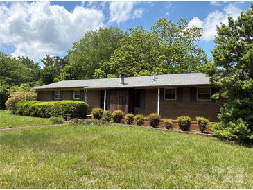 Charming brick home featuring manicured landscaping, a well-maintained lawn, and inviting curb appeal at 947 Ravendale Dr, Charlotte, NC 28216