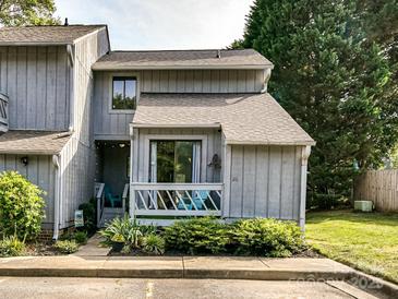 Charming townhome featuring a cozy porch, landscaped garden, and a well-maintained gray wood facade at 100 Willow Run Dr # 26, Gastonia, NC 28056