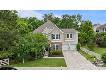 Charming two-story home with stone accents, manicured lawn, two-car garage, and lush landscaping at 1104 Snowbird Ln, Waxhaw, NC 28173