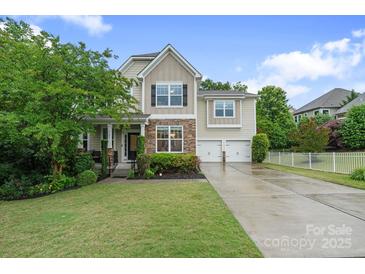 Charming two-story home with stone accents, manicured lawn, and a two-car garage at 1104 Snowbird Ln, Waxhaw, NC 28173