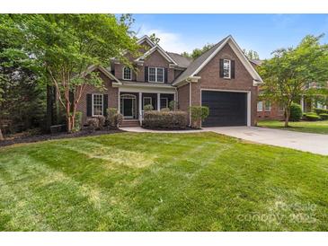 Charming brick home featuring a manicured lawn, two-car garage, and classic architectural details at 2213 Normandin Ct, Charlotte, NC 28216