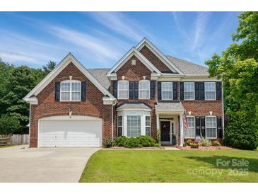 Traditional two-story brick home featuring black shutters, bay window, well-kept lawn, and an attached two-car garage at 2763 Rivendale Ct, Indian Land, SC 29707