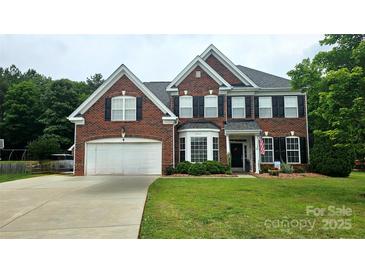Charming two-story brick home features a well-manicured lawn and an attached two-car garage at 2763 Rivendale Ct, Indian Land, SC 29707