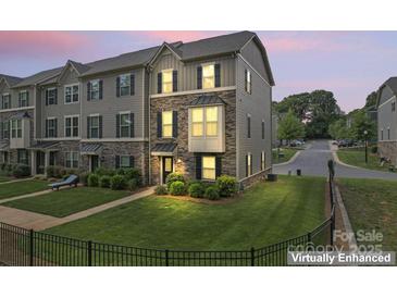 Beautiful townhome with stone accents, well-manicured lawn, and inviting curb appeal at dusk at 3003 Salix Bend Dr, Charlotte, NC 28205